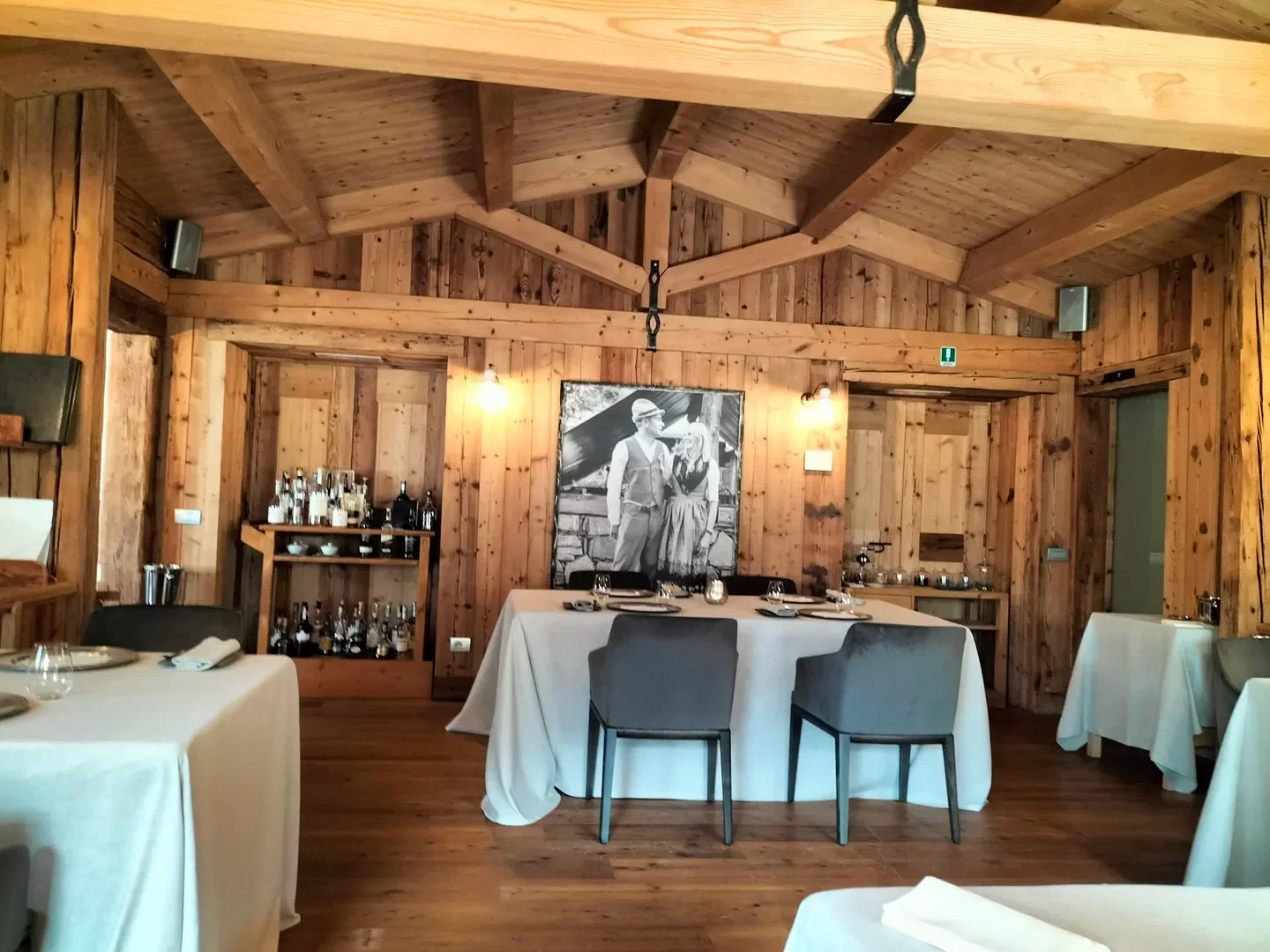 Cozy dining room at La Preséf restaurant in Lake Como with wood interior and table setting.